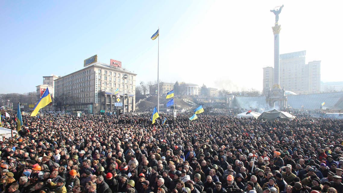 People listen to police officers from Lviv who have joined anti-government protesters as they speak from a stage during a rally in Independence Square in Kiev, Feb. 21, 2014. (Reuters)