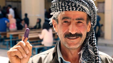 An Iraqi Kurdish man shows his ink-stained finger after voting during regional parliamentary elections at a polling station in Arbil