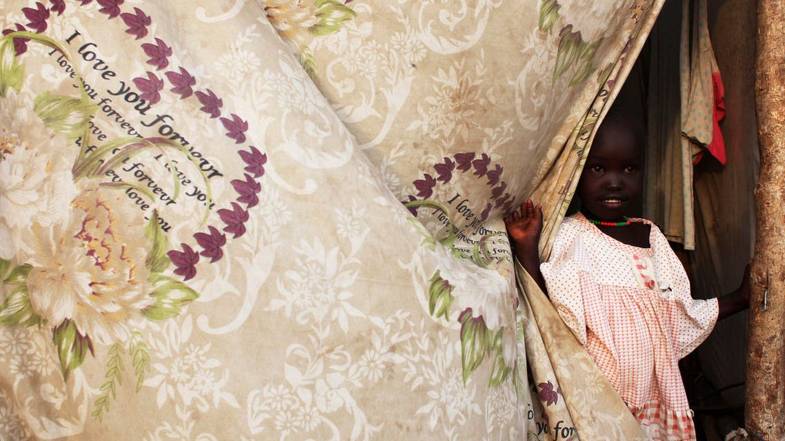 A South Sudanese girl displaced by the fighting stands next to a curtain in a camp for displaced persons in the UNMISS compound in Tongping in Juba February 19, 201