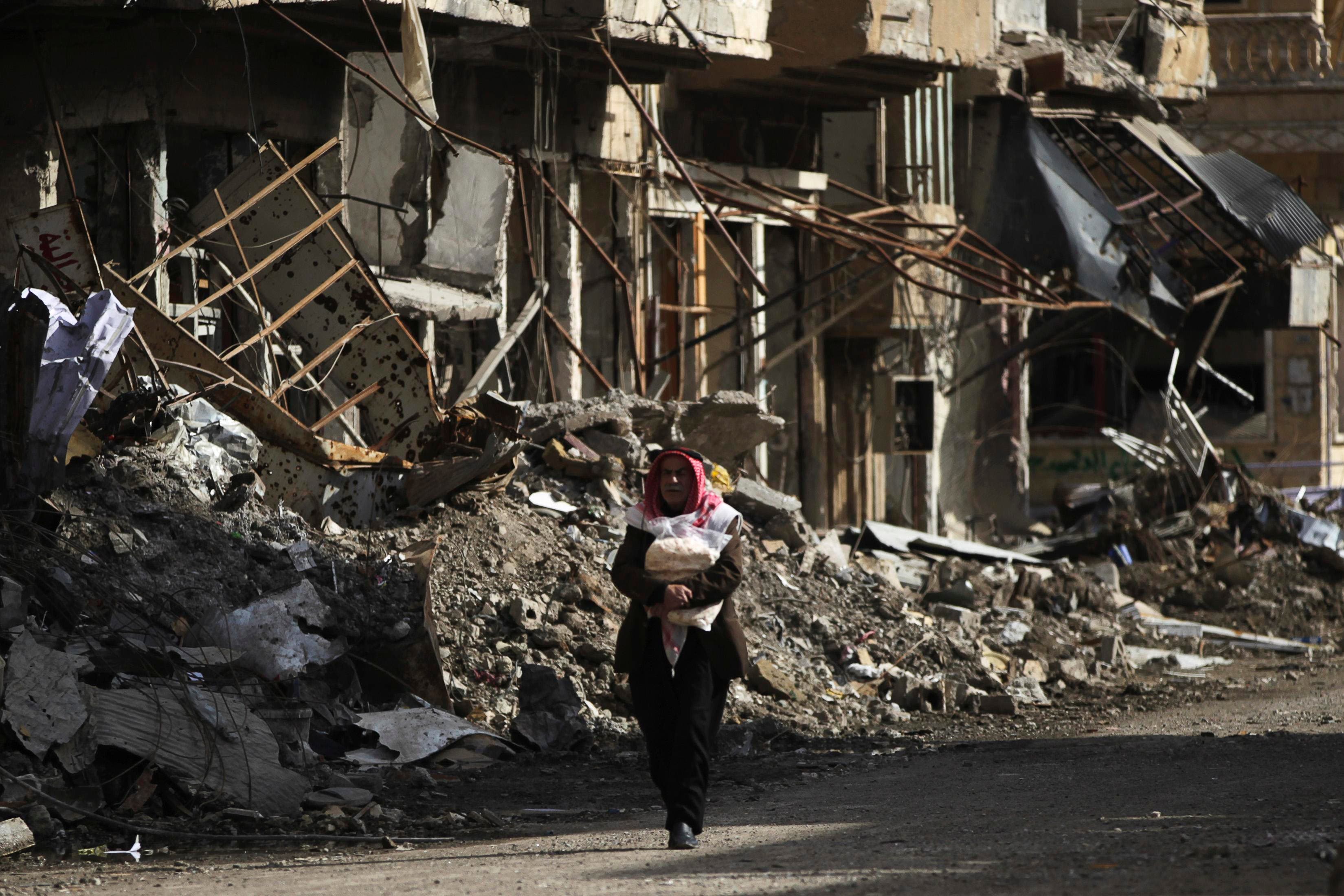 אזרח סורי נושא לחם למשפחתו בדיר אזור שבסוריה
