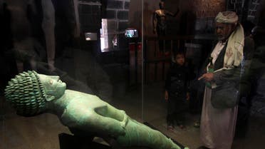 A man looks at an ancient bronze statue of Yemeni King Hawtar Athat, at the National Museum in Sanaa. (File photo Reuters)