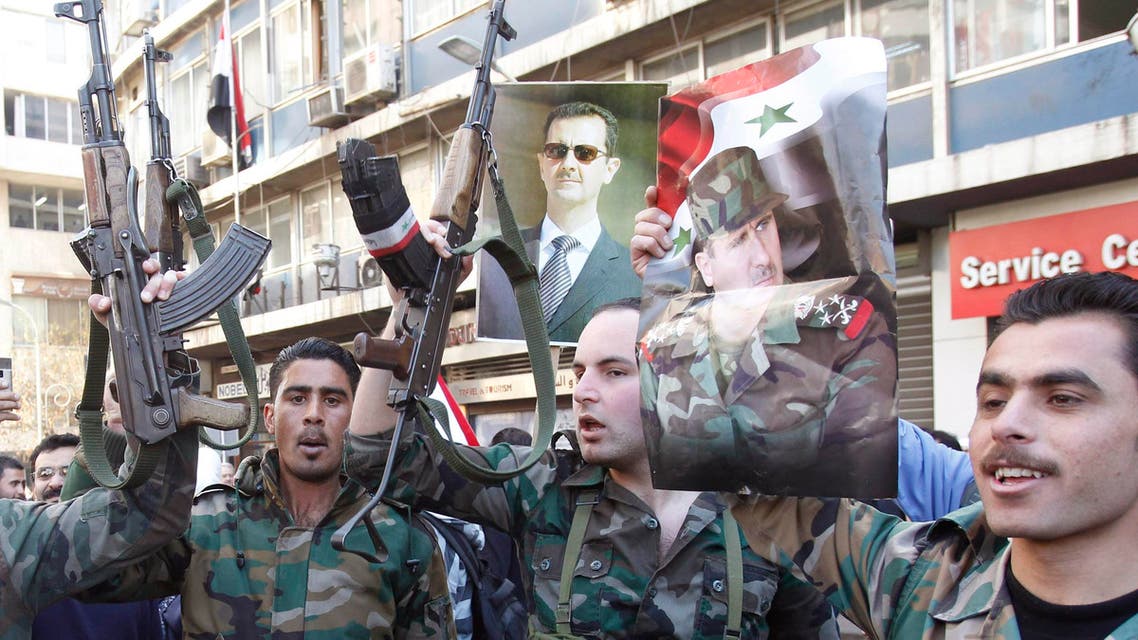 عناصر من جيش النظام ترفع صورة الاسد