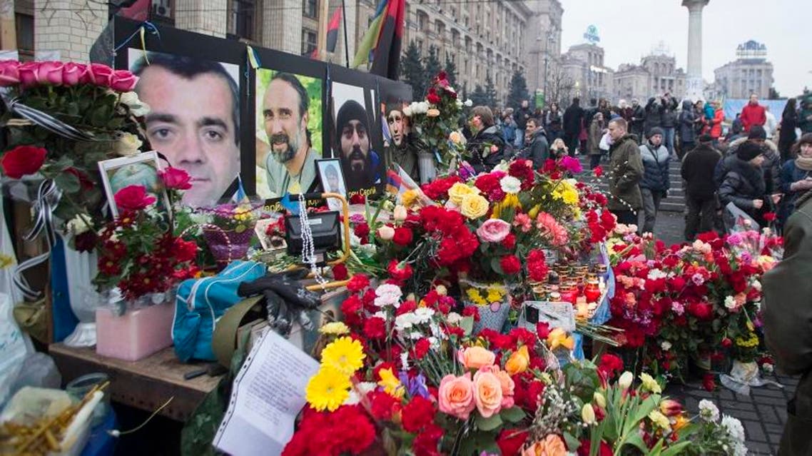 People place flowers at a makeshift memorial as they gather to commemorate the victims of the recent clashes in central Kiev February 23, 2014