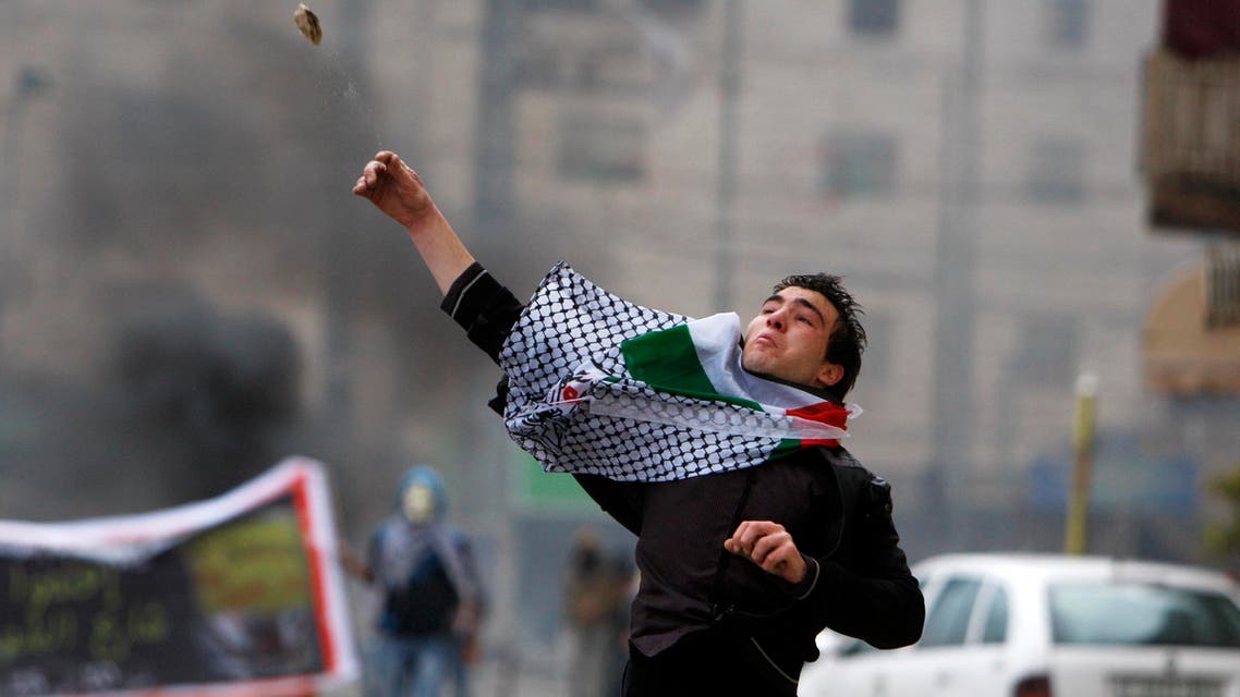 A Palestinian protester hurls a stone towards Israeli security forces during clashes at a protest against the closure of Shuhada street to Palestinians, in the West Bank city of Hebron February 24, 2012. 