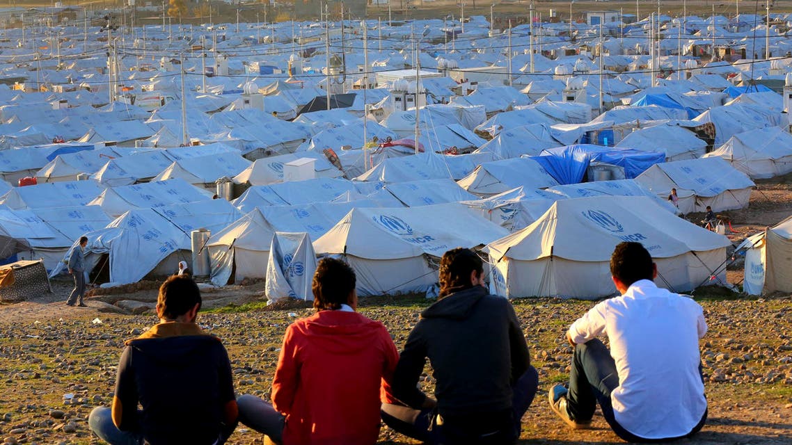 Young Syrian refugees sit in front of Quru Gusik refugee camp on the outskirts of Arbil, in Iraq's Kurdistan region, February 13, 2014