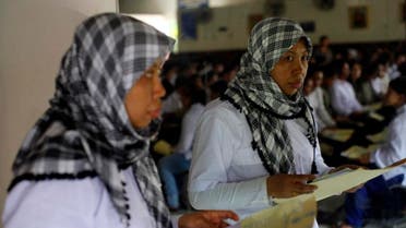 A migrant worker heading for Middle East countries holds her passport documents at an immigration office in Tangerang, Indonesia's Banten province, June 23, 2011. Ireuters