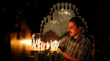 A Palestinian Orthodox Christian lights candles as he takes part in the Christian Orthodox Holy Fire ceremony at the Saint Porfirios church in Gaza City May 4, 2013. reuters