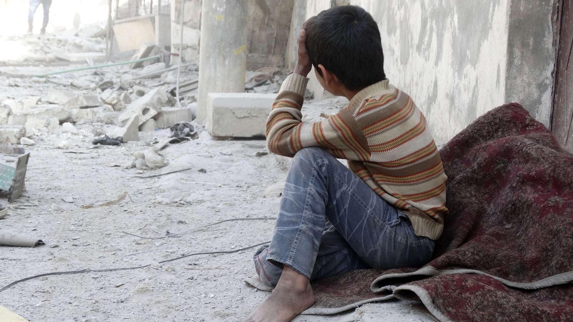 A Syrian child reacts following an air strike attack by government forces on the northern Syrian city of Aleppo on February 22, 2014.