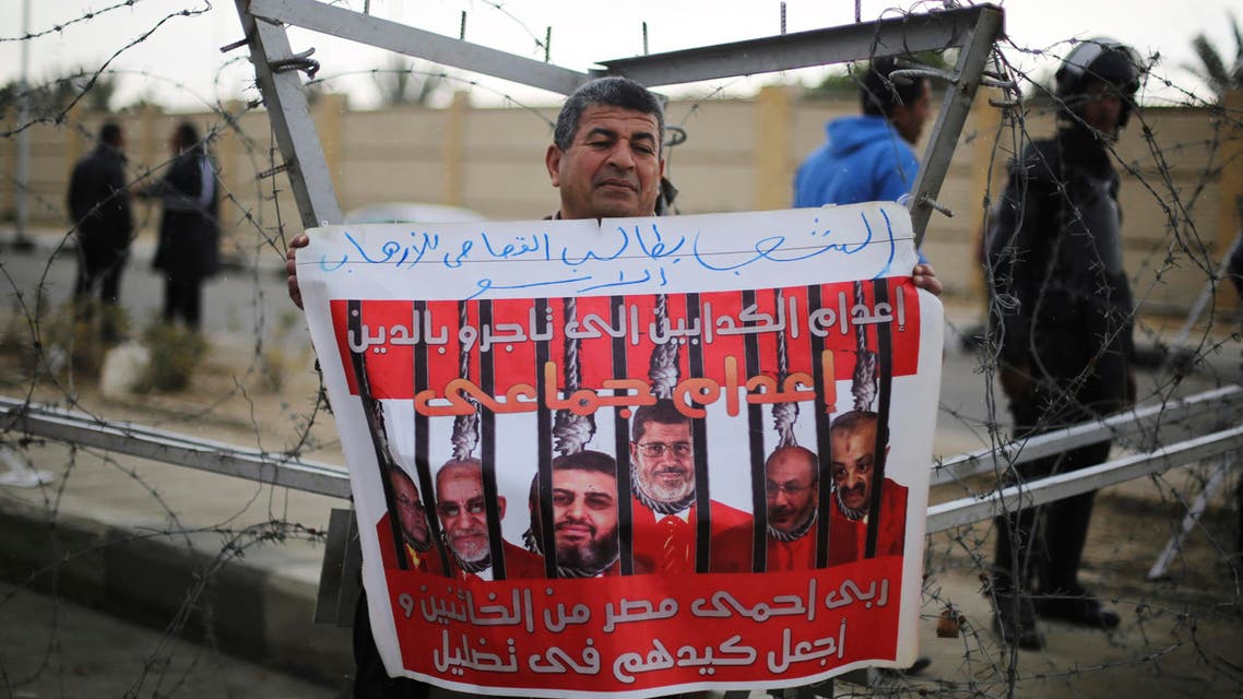 A supporter of Egypt's army chief Field Marshal Abdel Fattah al-Sisi rallies outside a police academy, where the trial of ousted Egyptian President Mohamed Mursi and members of the Muslim Brotherhood is due to take place, on the outskirts of Cairo, February 16, 2014 reu