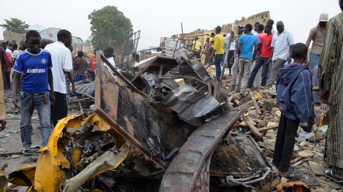 People look at damage in a market area after a bomb explosion in Ajilari-Gomari near the city's airport, Maiduguri, Borno State, March 2, 2014. (Reuters)