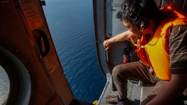 An officer looks out of a helicopter during a mission to find the Malaysia Airlines flight MH370 that disappeared from radar screens in the early hours of Saturday, near Tho Chu island March 10, 2014. (Reuters)        