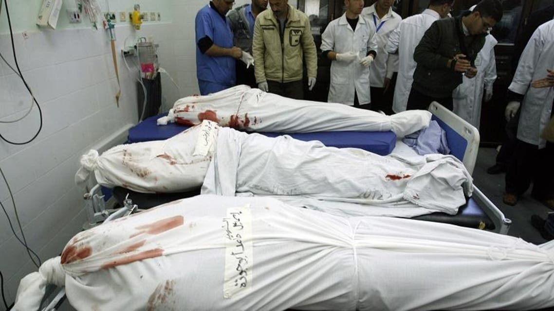 Palestinian medics check the shrouded bodies of three killed militants from the Islamic Jihad's armed wing, the Al-Quds Brigades, at the hospital morgue before their burial in Khan Yunis following an Israeli air strike in the southern Gaza Strip, on March 11, 2014.