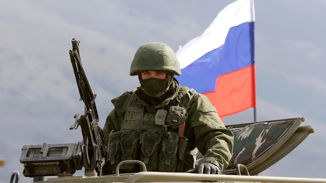 An armed man, believed to be a Russian serviceman, stands guard outside a Ukrainian military base in Perevalnoye, near the Crimean city of Simferopol, March 14, 2014.
