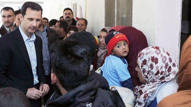 Syria’s President Bashar al-Assad speaks with children during his visit to displaced Syrians in the town of Adra in the Damascus countryside March 12, 2014. (Reuters)