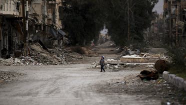 A child walks along a damaged street covered with debris in Deir al-Zor, eastern Syria February 3, 2014. (Reuters)