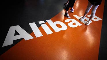 Employees stand on a logo of Alibaba (China) Technology Co. Ltd during a media tour organised by government officials at its headquarters on the outskirts of Hangzhou, Zhejiang province June 20, 2012.