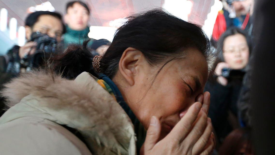 A relative of a passenger onboard Malaysia Airlines flight MH370 cries, surrounded by journalists, at the Beijing Capital International Airport in Beijing March 8, 2014 reuters