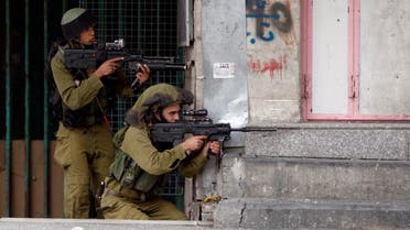 Israeli soldiers take position during clashes with stone-throwing Palestinians that followed a rally to support President Mahmoud Abbas in the West Bank city of Hebron March 17, 2014. reuters