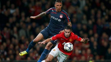 Manchester United's Robin van Persie (front) is fouled for penalty from Olympiakos' Jose Holebas during their Champions League soccer match at Old Trafford in Manchester, northern England, March 19, 2014. (Reuters)