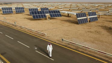 A Saudi man walks on a street past a field of solar panels at the King Abdulaziz city of Sciences and Technology, Al-Oyeynah Research Station May 21, 2012.
