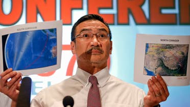 Malaysia's acting Transport Minister Hishammuddin Hussein shows two maps with corridors of the last known possible location of the missing Malaysia Airlines MH370 plane. (Reuters)