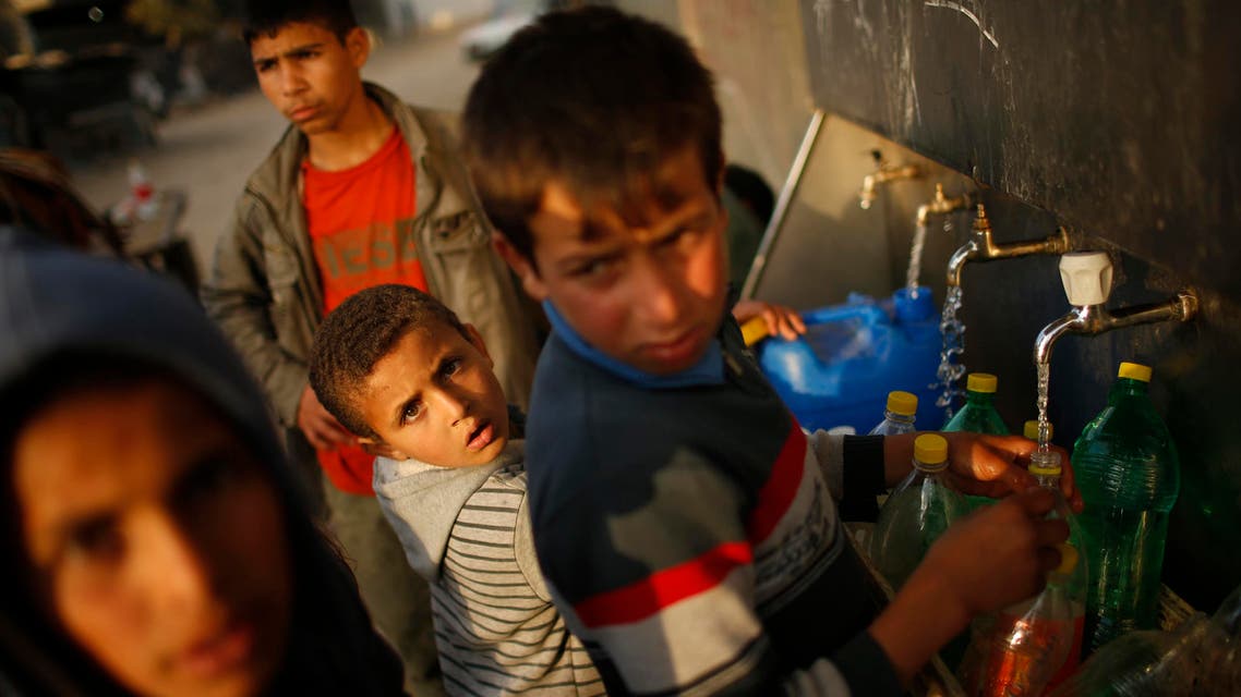 Palestinians fill containers with water from public taps in Beit Lahiya, near the border between Israel and the northern Gaza Strip. Reuters