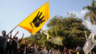 supporters of the Muslim Brotherhood and ousted Egyptian President Mohammad Mursi, wave a flag bearing the 'Rabaa' sign during a protest in front of at the main gate of the university in Cairo, Dec 9, 2013. (Reuters)