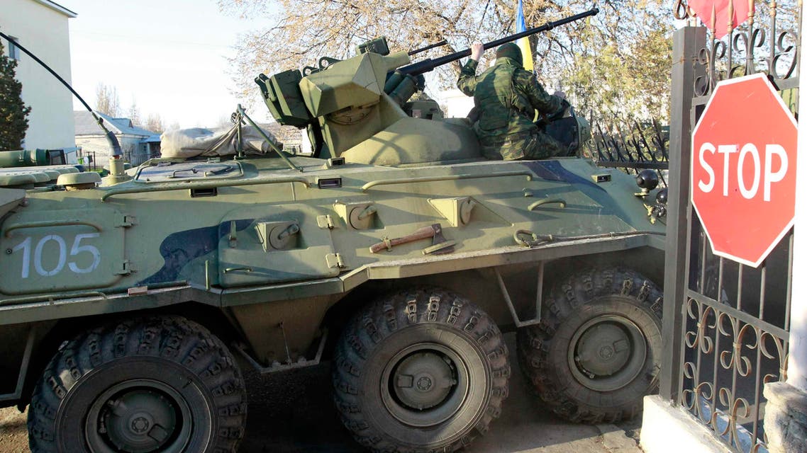 Armed men, believed to be Russian servicemen, drive an armoured vehicle onto the territory of a military airbase as they attempt to take over in the Crimean town of Belbek near Sevastopol March 22, 2014. (Reuters)