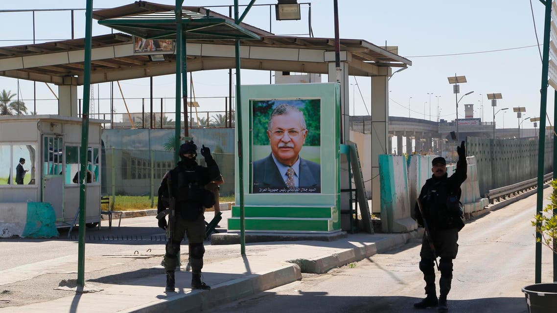 Iraqi SWAT troopers stand guard near a portrait of Iraqi President Jalal Talabani at a checkpoint outside the presidential compound as they replace Kurdish peshmerga guards in Baghdad's Jadriyah district March 23, 2014. (Reuters)