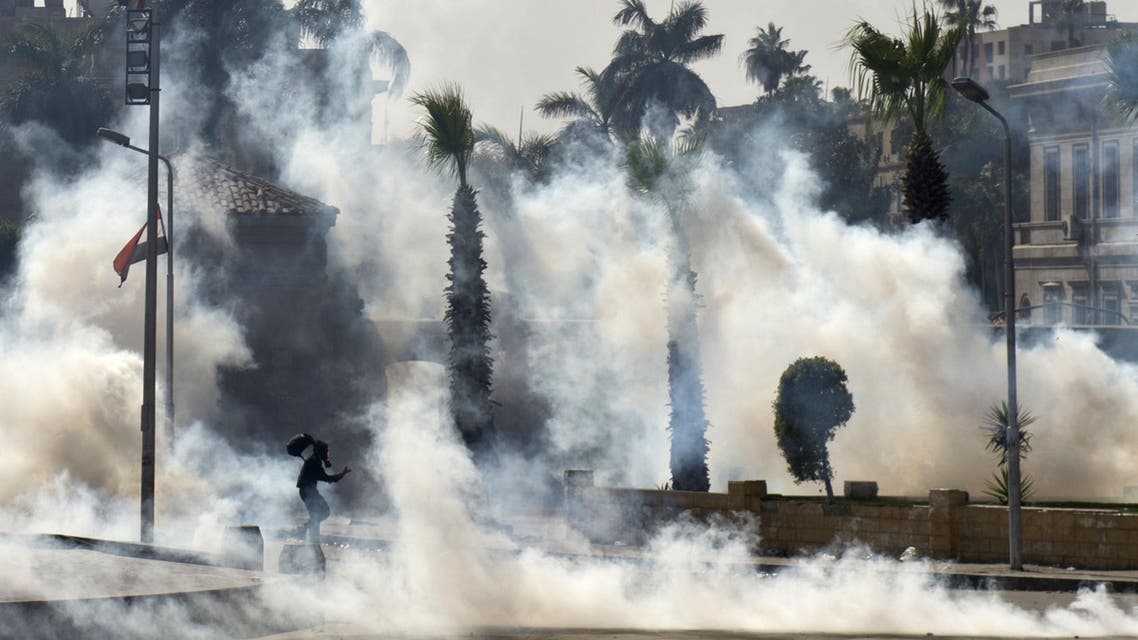 An Egyptian Muslim Brotherhood student and supporter of ousted president Mohammad Mursi runs through smoke during clashes with riot police following a demonstration outside Cairo University on March 26, 2014. (Reuters)