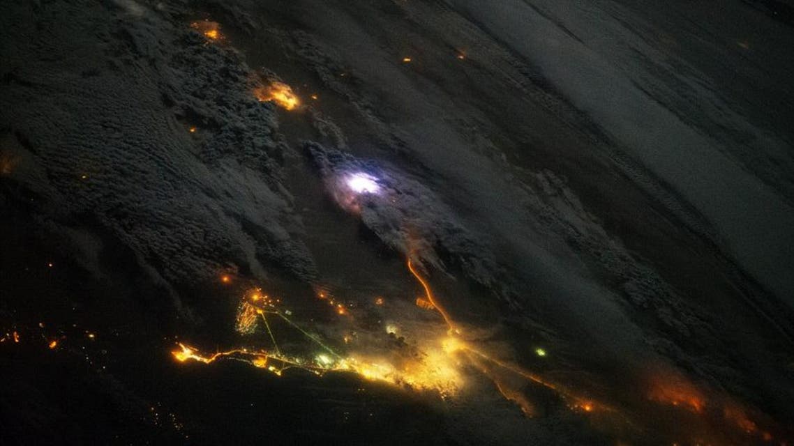 A white flash of lightning is seen over the Gulf, along with the city lights of Saudi Arabia and Kuwait, in this NASA picture taken on Dec 12, 2013. (Photo courtesy: NASA)