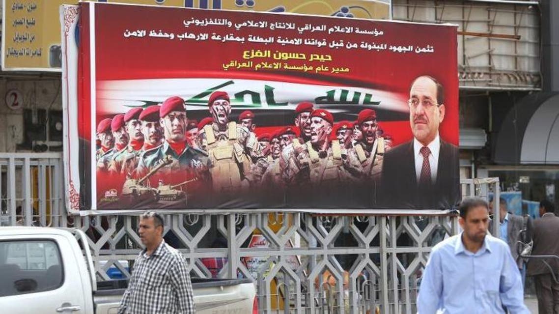 Iraqis walk past an election poster fronted by Iraqi Prime Minister Nuri al-Maliki (R) on March 25, 2014, in Baghdad, ahead of the parliamentary elections in April 2014 (AFP Photo/Ahmad al-Rubaye)