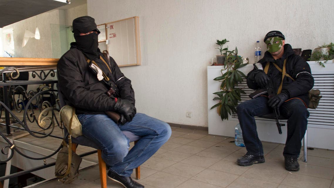 Masked armed men, believed to be pro-Russian protesters, sit inside the offices of the state security service in Luhansk, in eastern Ukraine April 7, 2014. (Reuters)