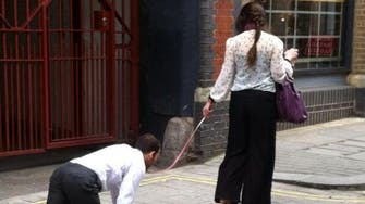 Woman walks businessman on leash in London