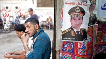 A man sits next to a poster of presidential candidate and former Egyptian army chief Field Marshal Abdel Fattah al-Sisi, in central Cairo, April 8, 2014. (Reuters)