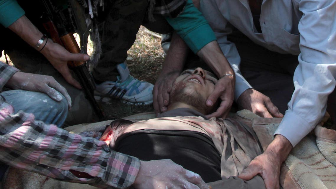 Rebel fighters mourn over the body of a comrade during his funeral on April 10, 2014 in the northern Syrian city of Aleppo.