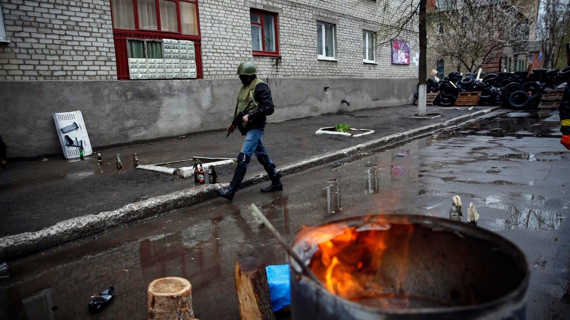 A pro-Russian armed man walks near the police headquarters in Slaviansk April 13, 2014. (Reuters)