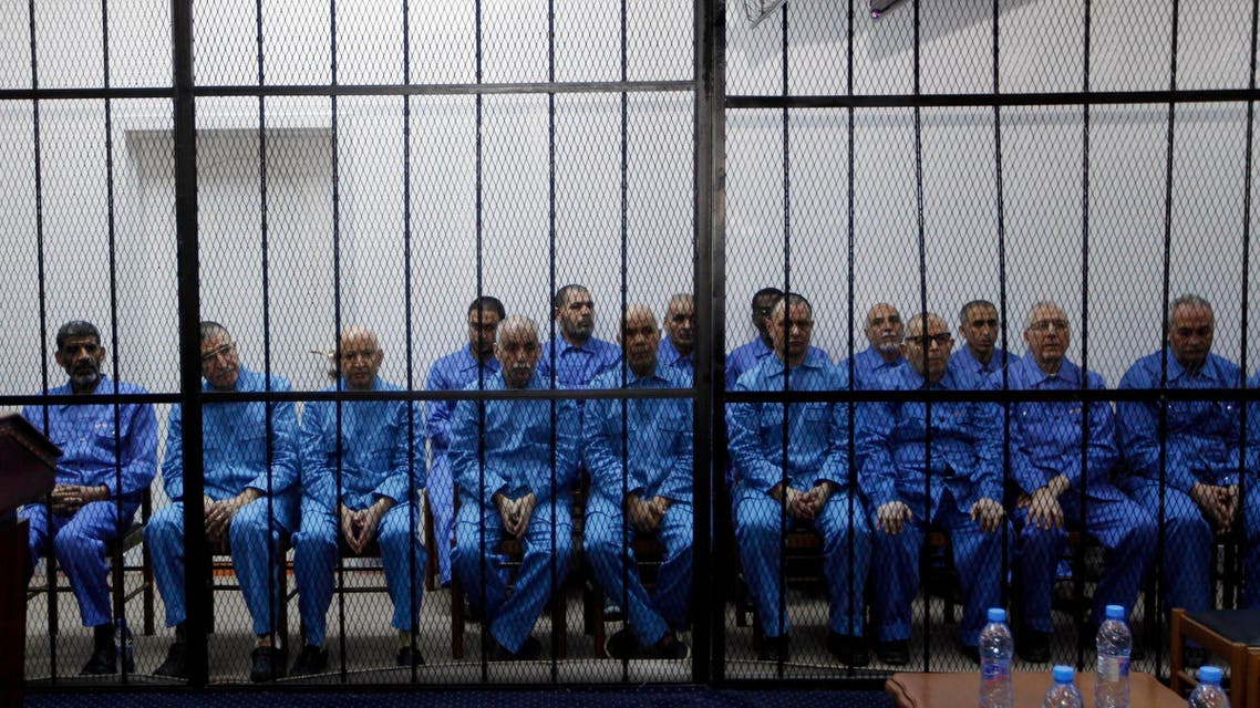 Officials of Muammar Qaddafi's government, including Abdullah al-Senussi (L), ex-spy chief and Buzeid Dorda (2nd L), ex-intelligence chief, sit behind bars during a hearing at a courtroom in Tripoli April 14, 2014. (Reuters)