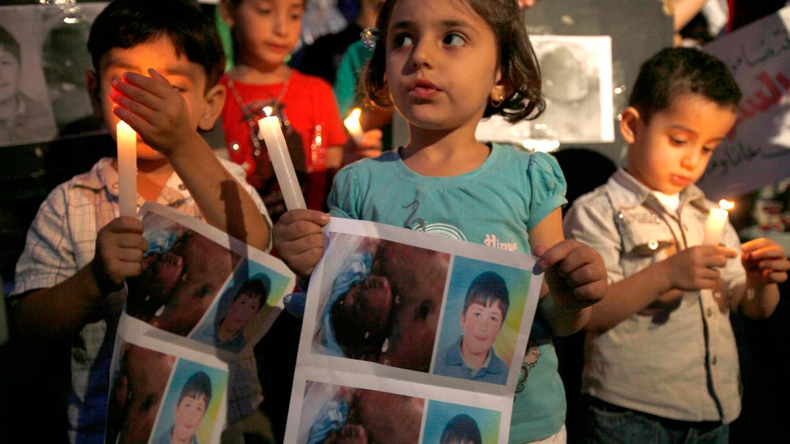 Syrian children carry pictures of 13-year-old Hamza al-Khatib and hold candles during a protest in front of the United Nations building in Beirut June 1, 2011. Reuters