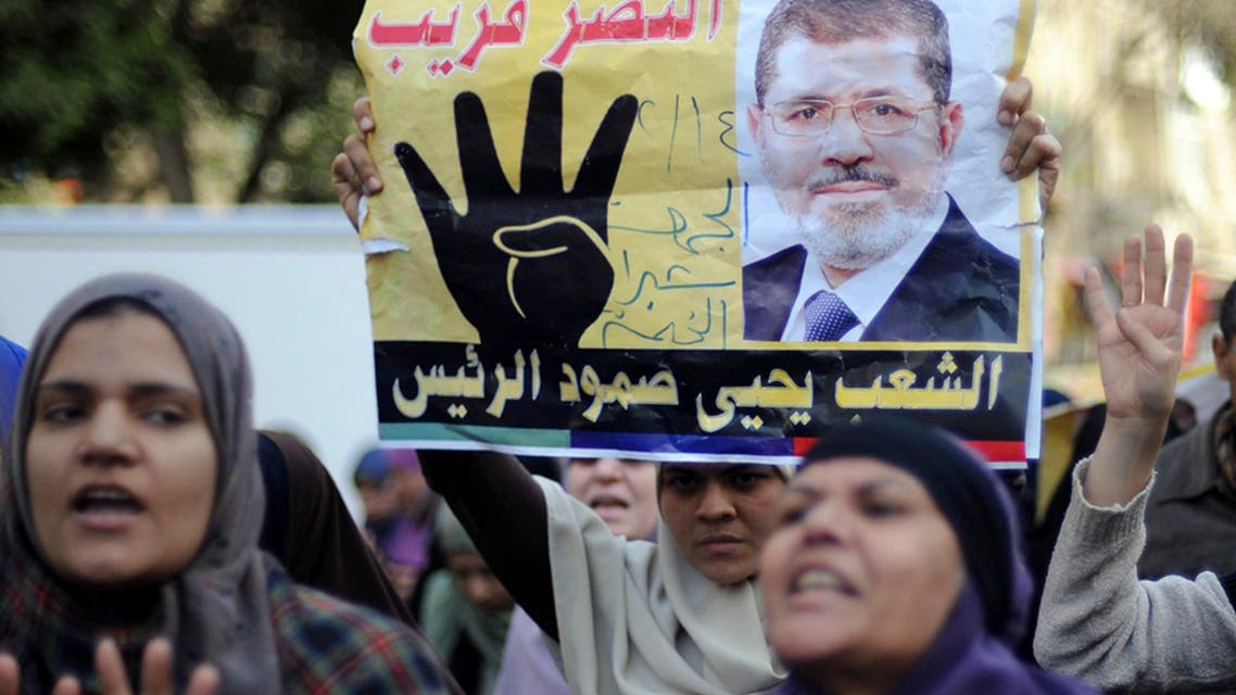 Supporters of Muslim Brotherhood and ousted Egyptian President Mohamed Mursi shout slogans against the military and the interior ministry as they gesture with the sign "Rabaa", or "Four", during a protest around Ain Shams square in east Cairo February 14, 2014. reuters