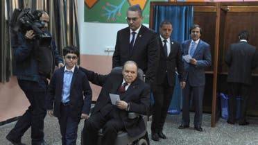 Algeria's ailing President Abdelaziz Bouteflika (C), running for re-election, is pushed in a wheelchair next to his nephew after casting his ballot at a polling station in Algiers on April 17, 2014.