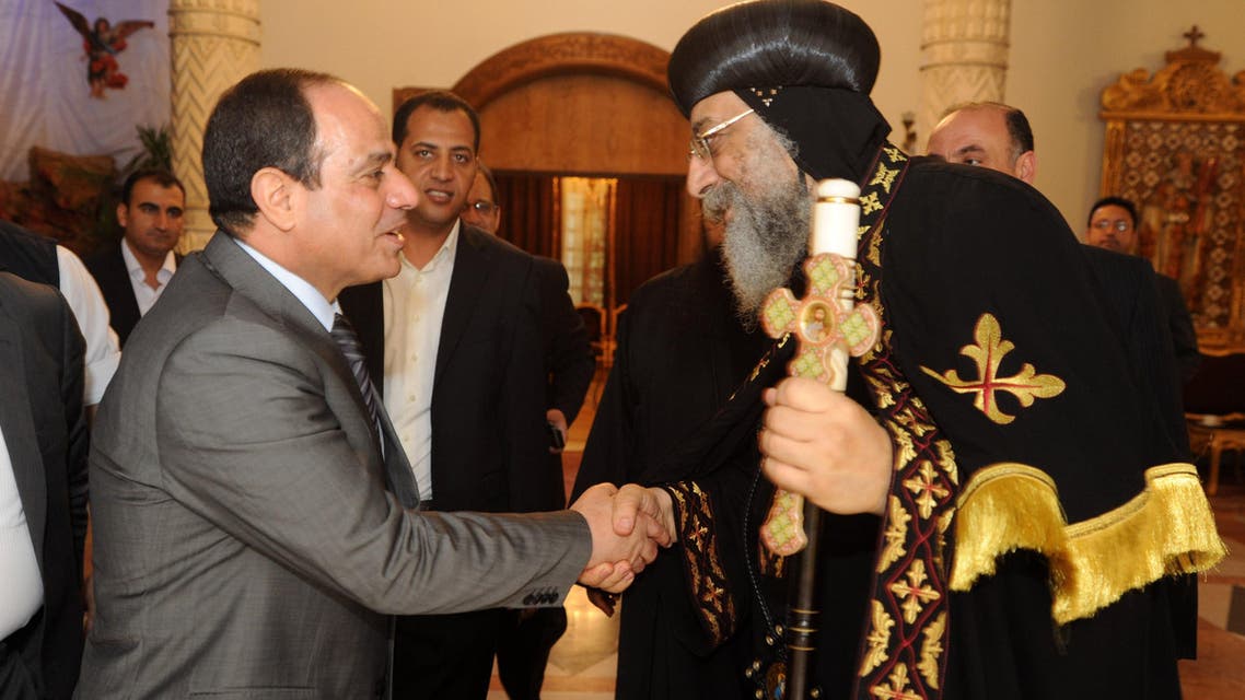 A handout picture released by the press office of Abbasiya Cathedral shows Egyptian former Defence Minister and armed forces chief General Abdul Fatah al-Sisi (L) shaking hands with Pope Tawadros II, pope of Egypt's Coptic Orthodox Church on April 19, 2014 during a visit at Cathedral of Abbasiya in Cairo. AFP