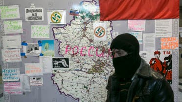 A pro-Russian separatists walk past a map a regional government building in Donetsk, in eastern Ukraine April 18, 2014. reuters