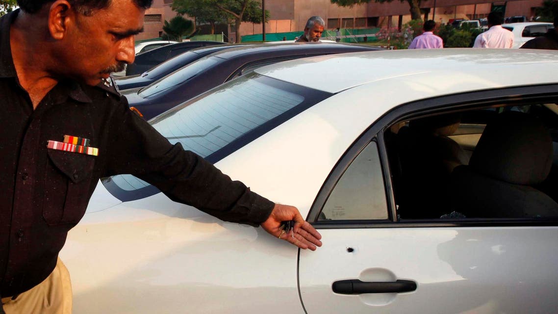 A policeman shows a bullet hole in a car belonging to journalist Hamid Mir. Unknown gunmen on motorcycles opened fire and injured Mir in Karachi on Saturday. (Reuters)