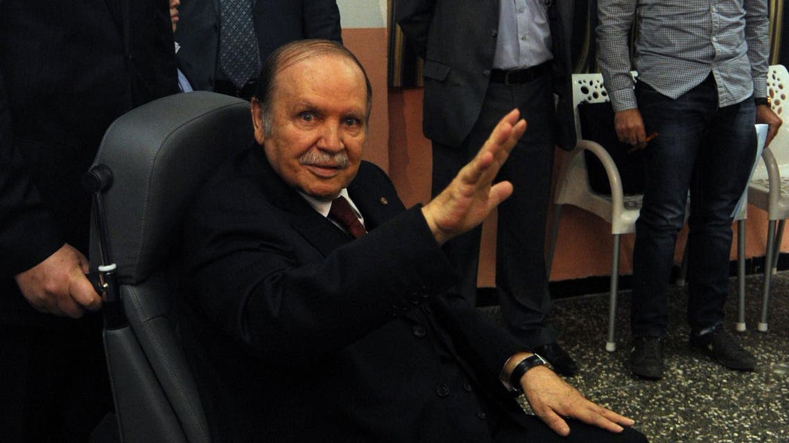 Algeria's ailing President Abdelaziz Bouteflika, running for re-election, waves as he is pushed in a wheelchair before voting at a polling station in Algiers afp