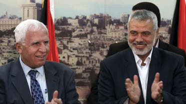 Palestinian Fatah delegation chief Azzam al-Ahmed (L) celebrates with Hamas prime minister in the Gaza Strip Ismail Haniya in Gaza City on April 23, 2014. (AFP)