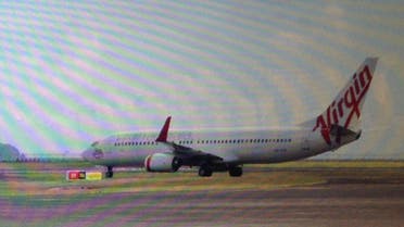  This photo taken through the window of a plane shows a Virgin Australia plane at the centre of a hijacking scare sitting on the tarmac at Bali airport in Denpasar on April 25, 2014.  (AFP)