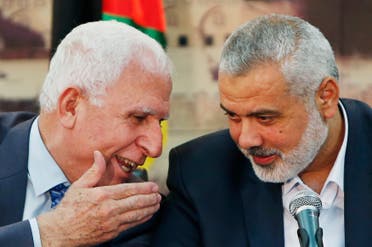 Senior Fatah official Azzam Al-Ahmed (L) speaks with head of the Hamas government Ismail Haniyeh as they announce a reconciliation agreement during a news conference in Gaza City April 23, 2014. (Reuters)