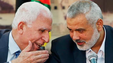 Senior Fatah official Azzam Al-Ahmed (L) speaks with head of the Hamas government Ismail Haniyeh as they announce a reconciliation agreement during a news conference in Gaza City April 23, 2014. (Reuters)