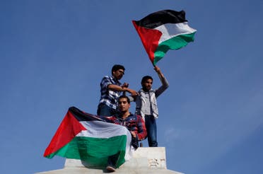 Palestinians hold national flags as they celebrate after an announcement of a reconciliation agreement in Gaza City April 23, 2014.  (Reuters)